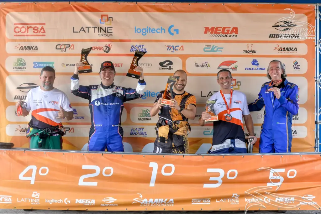 Pilotos no pódio de campeonato de kart segurando troféus, celebrando posições após corrida em evento organizado