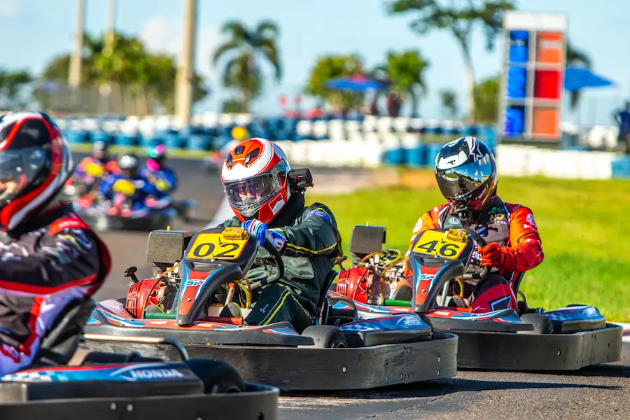 Pilotos disputam posição em corrida de kart rental, demonstrando a dinâmica e intensidade das corridas em pista outdoor.