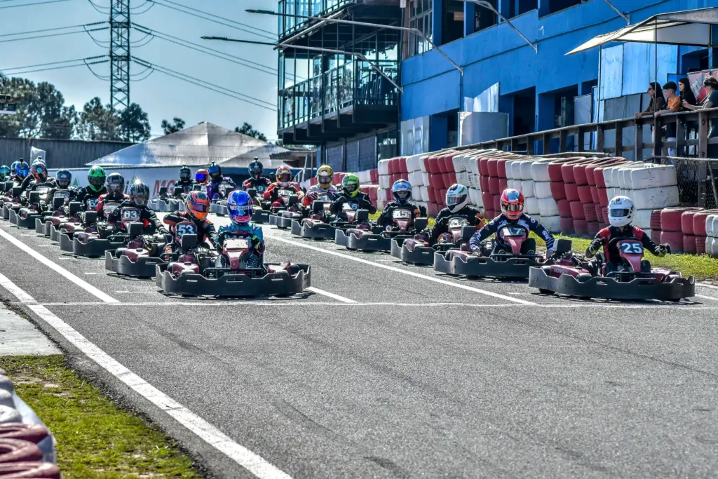 Pilotos de Rental Kart alinhados no grid de largada durante campeonato em kartódromo, aguardando o início da corrida.