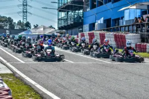 Pilotos de Rental Kart alinhados no grid de largada durante campeonato em kartódromo, aguardando o início da corrida.
