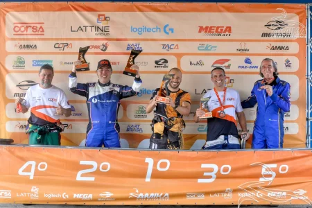Pilotos no pódio de campeonato de kart segurando troféus, celebrando posições após corrida em evento organizado