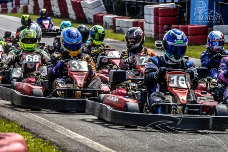 Pilotos disputando campeonato de rental kart em pista outdoor durante corrida competitiva.