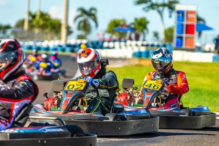 Pilotos disputam posição em corrida de kart rental, demonstrando a dinâmica e intensidade das corridas em pista outdoor.